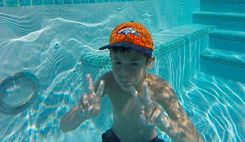 Kid with Broncos hat enjoying pool